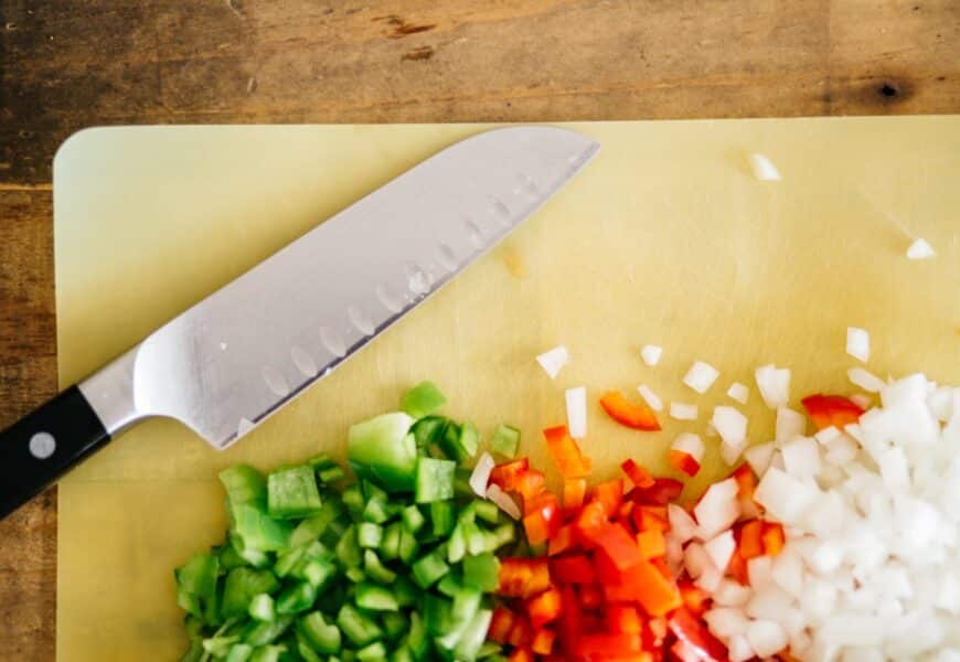 Découpe de divers légumes sur une planche à découper avec un couteau professionnel