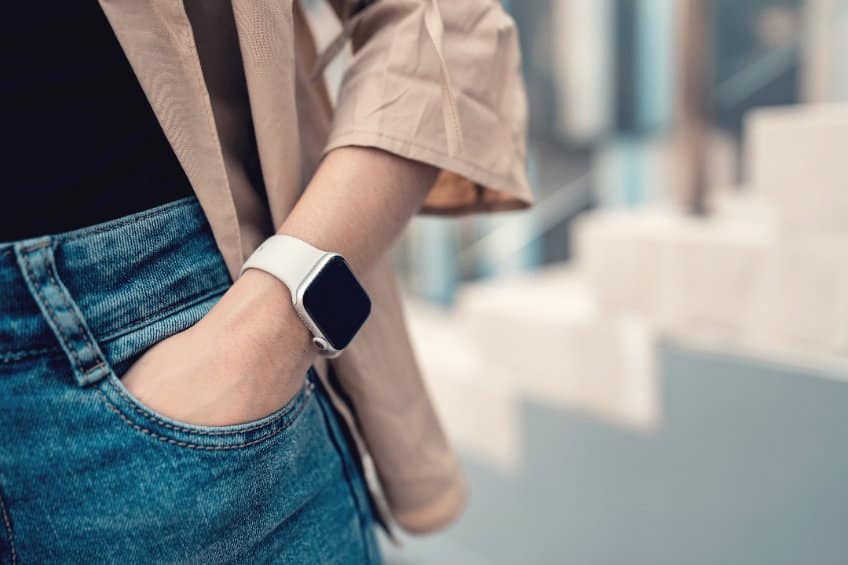 Femme au style casual portant une montre connectée avec un bracelet blanc au poignet