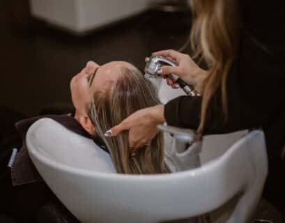 Femme qui se fait faire un shampoing chez le coiffeur