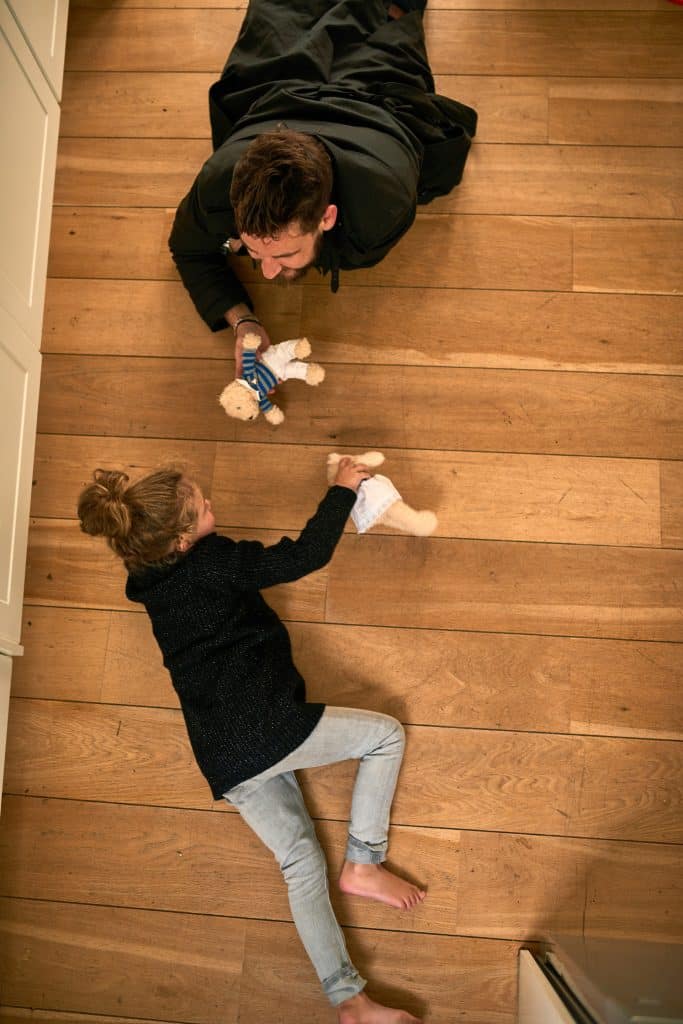 Père et fille jouant sur un parquet